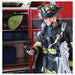 Firefighter in full gear holding a GX-6100 in a fire station.